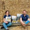 Will and Liz sitting on a pile of Barley Straw with all three Barley Straw products